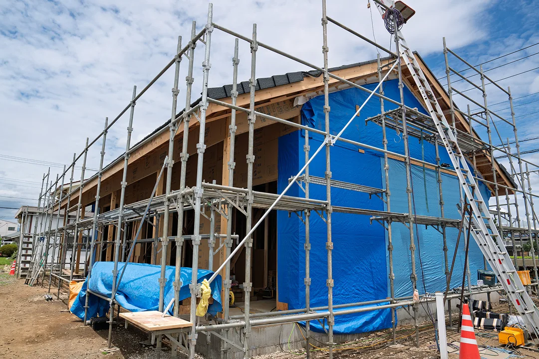 足場を組んで建方中の木造住宅